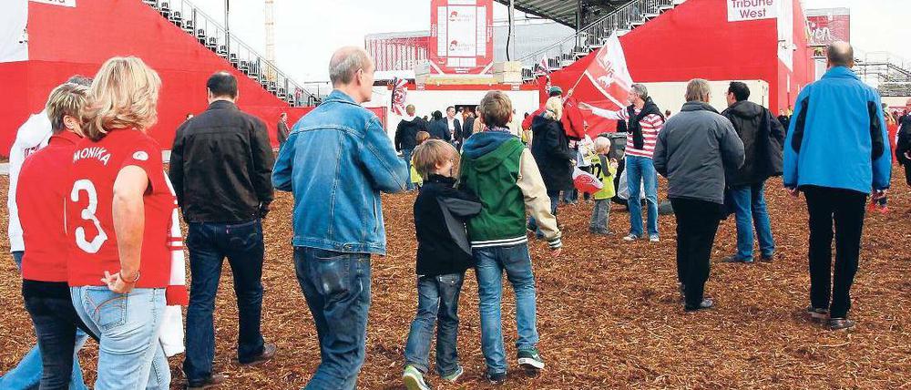 Drei-Spiele-Heimat. Über zerkleinerte Baumrinde schreiten Düsseldorfs Fans zu den improvisierten Tribünen. Im Hintergrund ist das eigentliche Stadion zu erkennen. Foto: dpa