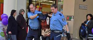 Polizisten beim Abführen des Tatverdächtigen.