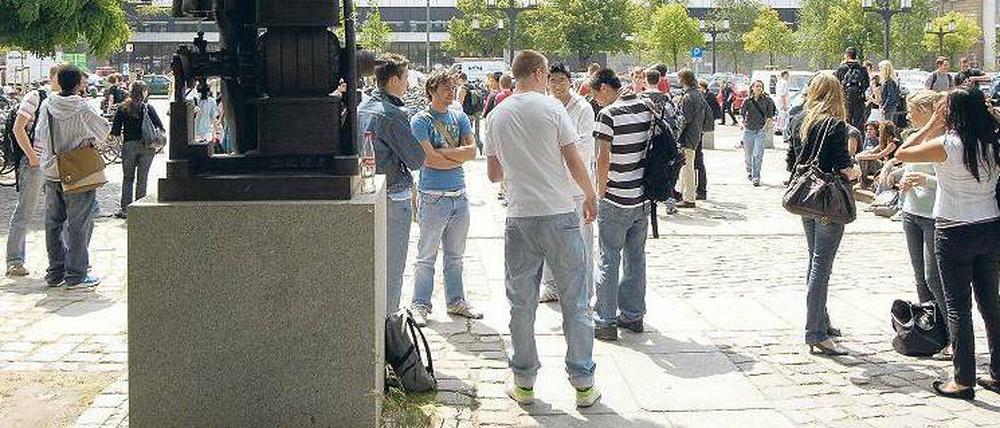 Auf dem TU-Campus. Studierende vor dem Hauptgebäude auf der Straße des 17. Juni. Im Vordergrund steht eine Siemens-Statue.