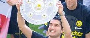 Zwei Hände an der Schale. Sahin hatte großen Anteil am Meistertitel des BVB. Foto: dpa