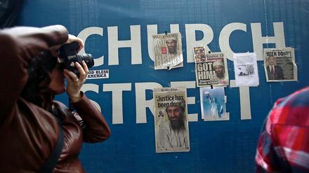 Am Zaun, der Ground Zero in New York umgibt, hängen Zeitungsartikel über den Tod von Osama bin Laden.