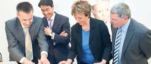 Blick untern Kittel. Bundesgesundheitsminister Philipp Rösler (2.v.l.) in der Charité.