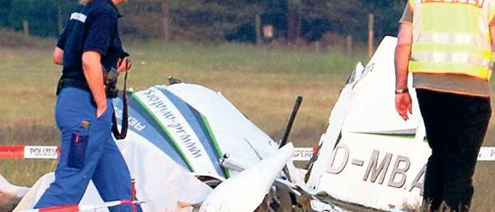 Ein Trümmerhaufen. Polizisten am Wrack des Ultraleichtflugzeuges. Foto: Paul Zinken