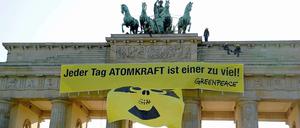 Mit Gelb-Schwarz gegen Schwarz-Gelb: Greenpeace demonstriert am Brandenburger Tor für einen raschen Atomausstieg. Die Bundesregierung einigte sich in der Nacht zu Montag auf einen Ausstieg bis spätestens 2022.