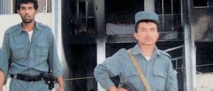 Nach dem Anschlag. Afghanische Polizisten stehen vor dem Eingang des Gouverneursgebäudes von Talokan, wo bei dem Attentat vom Samstag sieben Menschen getötet worden waren. 