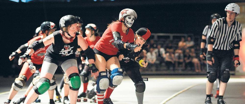 Vorfahrt Totenkopf. Die Frau, die sich beim Roller Derby Tequila Knockout nennt, kämpft sich durch die Meute.