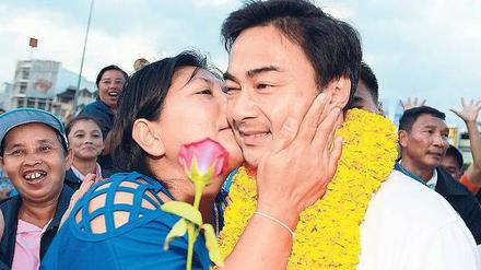 Der Kuss sitzt. Der thailändische Premierminister Abhisit Vejjajiva auf Wahlkampftour. Doch seine Partei hat seit 1992 keine Wahl mehr gewonnen und er kam nur dank der Militärs an die Macht. Laut Umfragen wird er in zwei Wochen gehen müssen. Foto: dpa