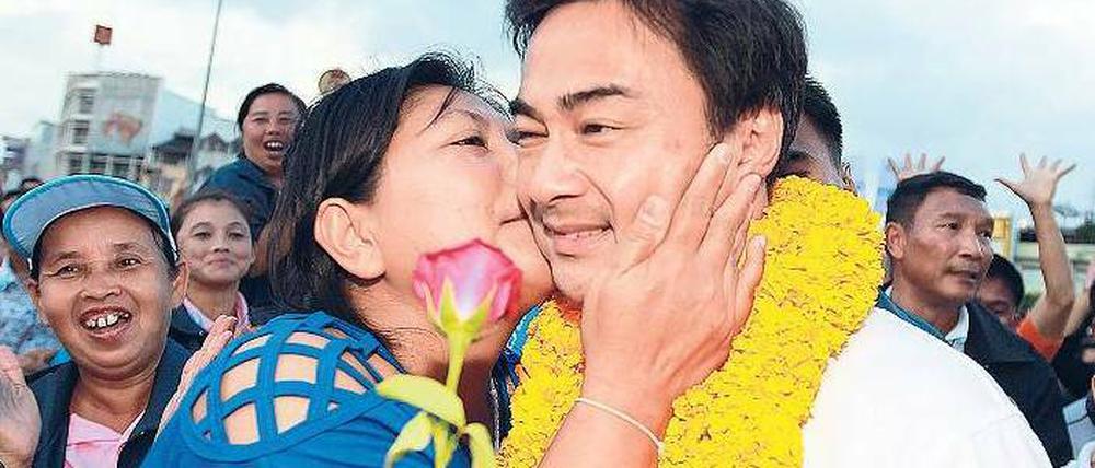 Der Kuss sitzt. Der thailändische Premierminister Abhisit Vejjajiva auf Wahlkampftour. Doch seine Partei hat seit 1992 keine Wahl mehr gewonnen und er kam nur dank der Militärs an die Macht. Laut Umfragen wird er in zwei Wochen gehen müssen. Foto: dpa 