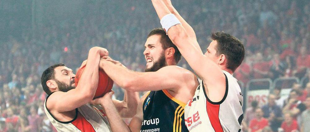 Den Traum entrissen. Die Bamberger Predrag Suput (links) und Casey Jacobsen (rechts) nehmen Alba Berlins Miroslav Raduljica den Ball – und die Hoffnung auf den Titel. Foto: dapd
