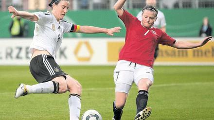 Haltung bewahren. Birgit Prinz (l.), hier im Zweikampf mit Norwegens Trine Rönning, trotzt derzeit noch der Konkurrenz von der deutschen Bank. Foto: dpa