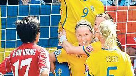 Leistungsträgerin. Schwedens Torschützin Lisa Dahlkvist (Mitte) schultert Jessica Landstrom. Foto: dapd