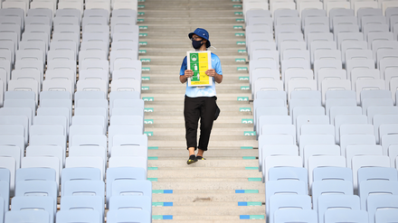 Neuer olympischer Dreikampf: Ein Volunteer erinnert im fast leeren Stadion von Miyagi an das Maskentragen, Händewaschen und Abstandhalten.  Foto: Molly Darlington/Reuters