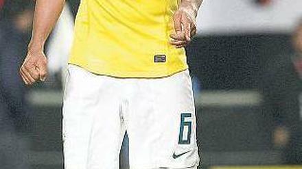 Da ist der Schuldige. Brasiliens André Santos zeigt auf den kaputten Rasen. Foto: AFP