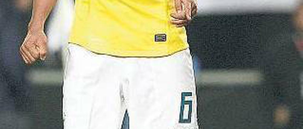 Da ist der Schuldige. Brasiliens André Santos zeigt auf den kaputten Rasen. Foto: AFP
