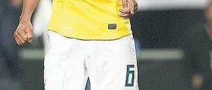 Da ist der Schuldige. Brasiliens André Santos zeigt auf den kaputten Rasen. Foto: AFP