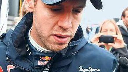 Trübe Gasse. Ein enttäuschter Sebastian Vettel bahnt sich nach dem vierten Platz auf dem Nürburgring seinen Weg durch die Menschenmenge. Foto: dpa