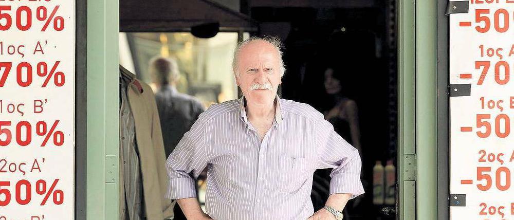 Es geht nach unten. Ein Ladenbesitzer in Athen vor seinem Geschäft – er muss Kunden mit heftigen Rabatten locken.