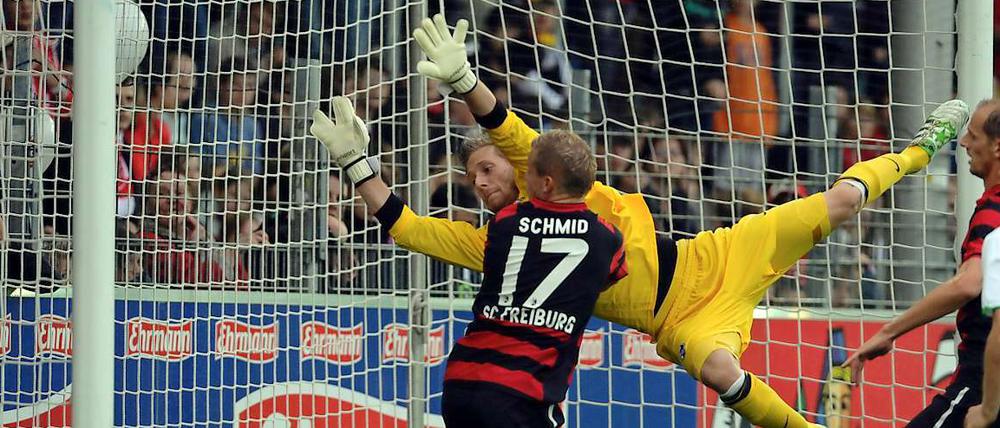 Torwart Oliver Baumann hechtet vergeblich nach einem Ball.