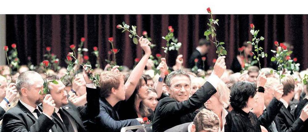 Den Ofern zu Ehren. Norwegische Sozialdemokraten mit Premier Jens Stoltenberg in der Mitte halten bei einer Gedenkveranstaltung für die von Anders Behring Breivig Ermordeten Rosen in den Händen. Foto: Berit Roald/dpa