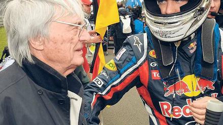 Der Brite gratuliert mit links. Auch Formel-1-Boss Bernie Ecclestone (hier auf dem Nürburgring) scheint kaum noch Zweifel an Vettels Titelgewinn zu haben. Foto: dapd