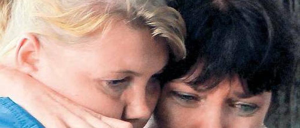 Am rettenden Ufer. Helfer betreuen Überlebende und Angehörige. Foto: Reuters