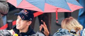 Interviews im Regen. Weltmeister Sebastian Vettel kommt kaum noch zur Ruhe – das gilt auch für viele andere Formel-1-Rennfahrer. Foto: dapd