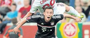 Klein gewinnt. Rafinha (unten) bringt seine 1,72 Meter im Testspiel geschickt gegen Antonio Cassana vom AC Mailand ein. Foto: AFP