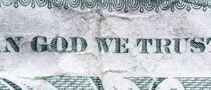 Gottvertrauen, wie auf der Dollar-Note gefordert, brauchen die Amerikaner noch mehr als sonst. Der Schuldenstreit könnte den Steuerzahler teuer zu stehen kommen.