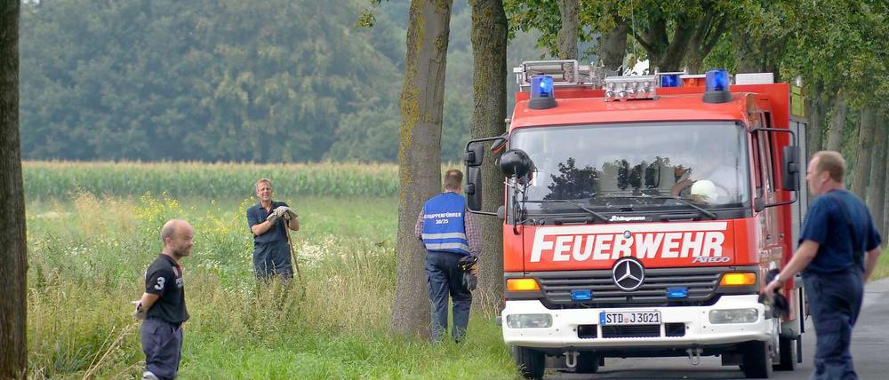 Feuerwehrleute durchsuchen am Samstag eine Wiese bei Buxtehude nach Leichenteilen.