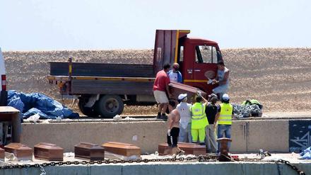 Freiwillige Helfer verladen die Särge mit den 25 Leichen, die auf dem völlig überfüllten Flüchtlingsboot aus Libyen gefunden worden waren.