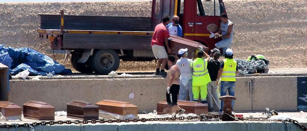 Freiwillige Helfer verladen die Särge mit den 25 Leichen, die auf dem völlig überfüllten Flüchtlingsboot aus Libyen gefunden worden waren.