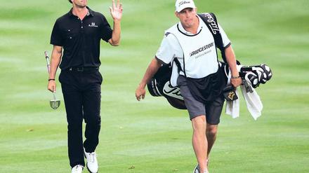 Last und Lust. Steve Williams (r.) brachte es zum berühmtesten Caddie der Welt und führte nun Adam Scott zum Sieg. Foto: Reuters