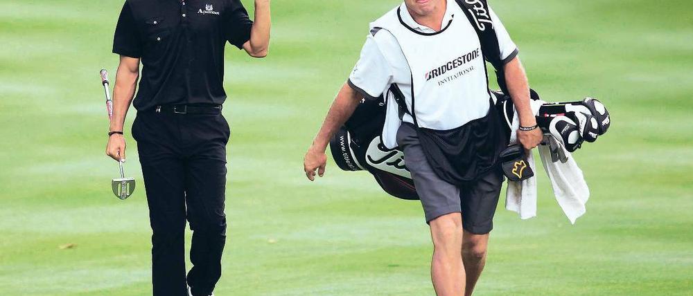 Last und Lust. Steve Williams (r.) brachte es zum berühmtesten Caddie der Welt und führte nun Adam Scott zum Sieg. Foto: Reuters