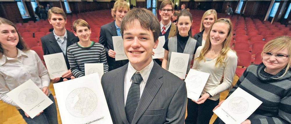 Jung und jünger. Erstsemester präsentieren ihre Immatrikulationsurkunden in Jena. Auch wegen Schnellläuferklassen starten Abiturienten früher ins Studium. Unis fragen sich jetzt: Darf heute noch Alkohol bei der Immafeier an Minderjährige ausgeschenkt werden?Foto: dpa