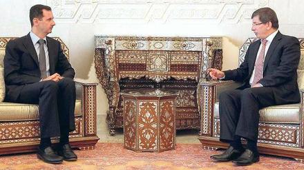 Angespannt ist inzwischen das Verhältnis der einstigen Freunde Syrien und Türkei. Auch das Treffen zwischen Präsident Baschar al Assad (links) und Ankaras Außenminister Ahmet Davutoglu in Damaskus verlief am Dienstag augenscheinlich nicht in lockerer Atmosphäre.