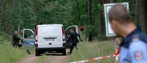Ein Leichenwagen steht am Freitag in einem abgesperrten Waldstück bei Börnicke (Havelland). Zwei tote Kinder waren in einem ausgebrannten Auto gefunden worden. 