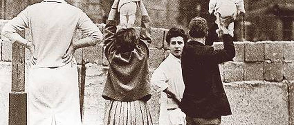 Gruß an die Großeltern. Die Aufnahme entstand im September 1961, als ein West- Berliner Elternpaar mit seinen Zwillingen zur Grenze fuhr. Foto: akg-images