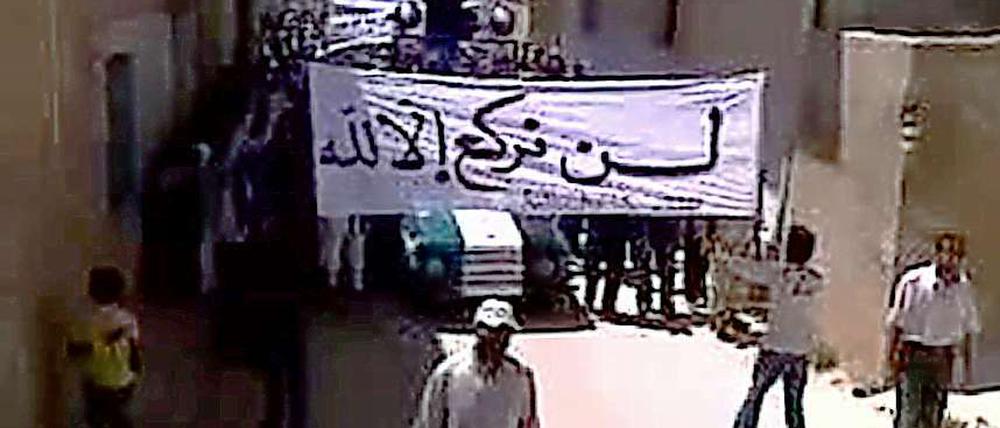 Das Standbild aus einem Youtube-Video zeigt Regierungsgegner mit einem Transparent, auf dem steht: "Wir knien nur vor Gott."