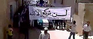 Das Standbild aus einem Youtube-Video zeigt Regierungsgegner mit einem Transparent, auf dem steht: "Wir knien nur vor Gott."