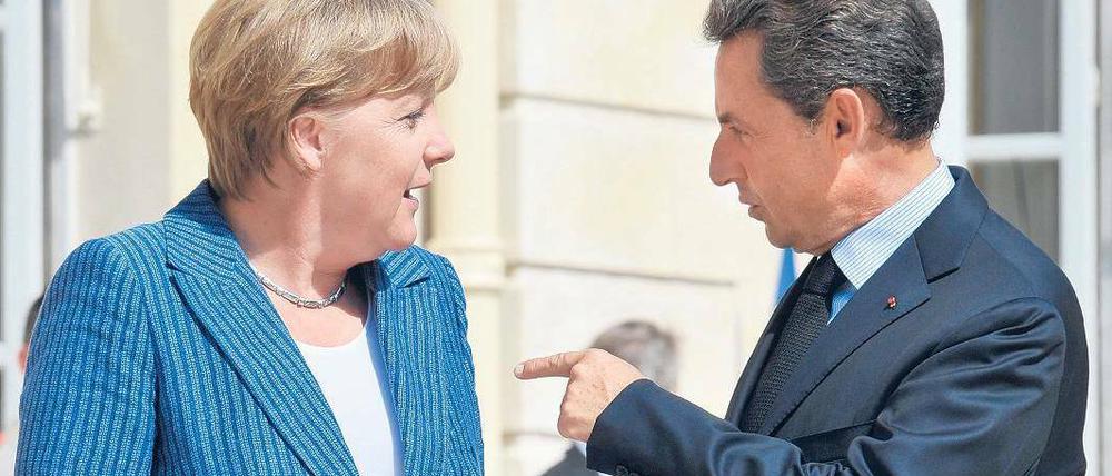 Entspanntes Gespräch. Bevor es ans Eingemachte ging, zeigten sich Merkel und Sarkozy am Dienstag auf den Stufen des Elysée-Palastes den Fotografen. Foto: Horacio Villalobos/dpa