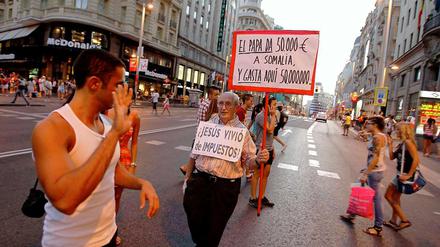 Wo der Heilige Stuhl ist, ist auch Protest. "Der Papst gibt Somalia 50000 Euro und spendet 50 Millionen hier", steht auf dem Schild des Mannes. "Hat Jesus von Steuern gelebt?", steht auf seiner Brust.