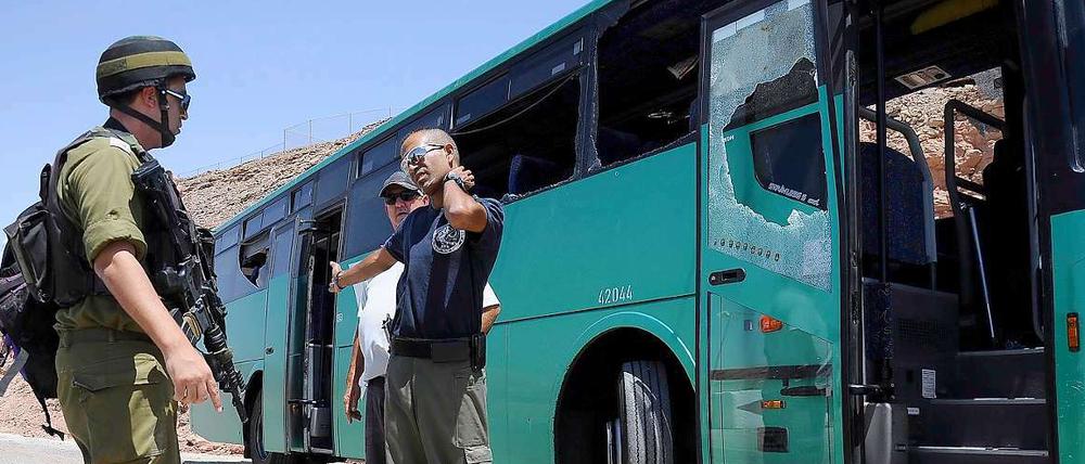 Israelische Einsatzkräfte neben dem beschossenen Bus.