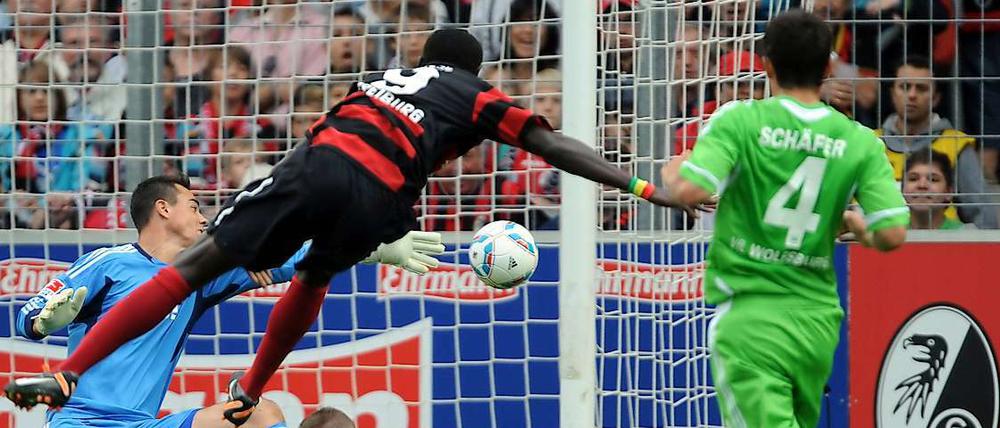 Freiburgs Toptorjäger Papiss Cisse kommt gegen den VfL Wolfsburg vor dem Ex-Herthaner Alexander Madlung zum Torschuss.