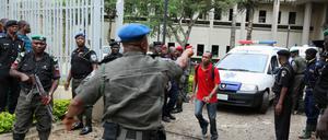 Hektik vor dem UN-Gebäude. Krankenwagen fahren Verletzte ins Krankenhaus. Ein UN-Mitarbeiter gibt dem Fahrer Anweisungen.