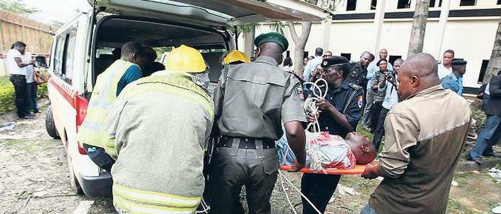 Tote und Verletzte. Helfer tragen ein Opfer des Anschlags von Abuja in einen Rettungswagen. Foto: Afolabi Sodtunde/Reuters