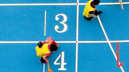Putzkolonne. Südkoreas Organisatoren tun alles für saubere Spiele – zumindest auf der Laufbahn. Foto: Reuters