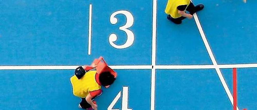 Putzkolonne. Südkoreas Organisatoren tun alles für saubere Spiele – zumindest auf der Laufbahn. Foto: Reuters