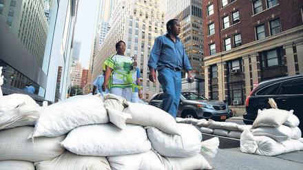 Hochwassersäcke säumen die Straßen in Downtown Manhattan. Dort werden starke Überflutungen befürchtet. Fotos: Reuters(2),Getty Images/AFP (1)