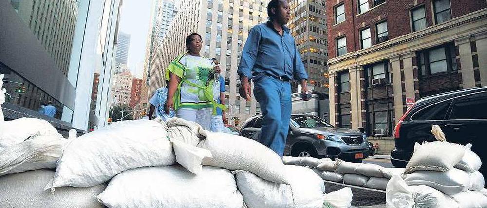 Hochwassersäcke säumen die Straßen in Downtown Manhattan. Dort werden starke Überflutungen befürchtet. Fotos: Reuters(2),Getty Images/AFP (1)