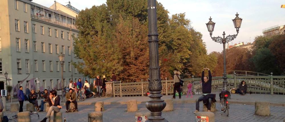 Goldener Herbst: Das Laub färbt sich am Landwehrkanal, auf der Admiralbrücke sitzen viele - vielleicht ein letztes Mal - draußen.